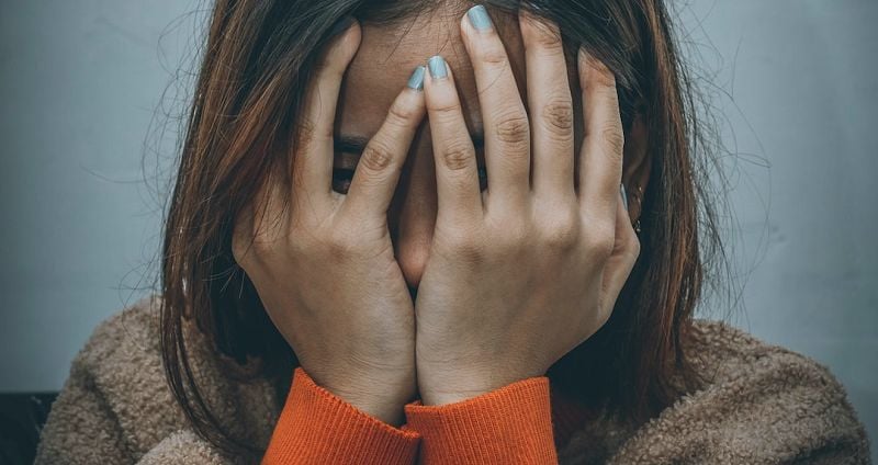 Sad women with hands in front of her face