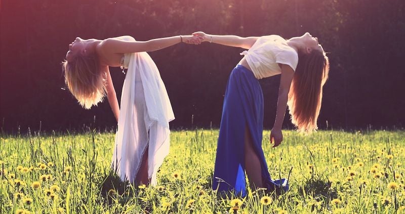 Two women in a field holding hands